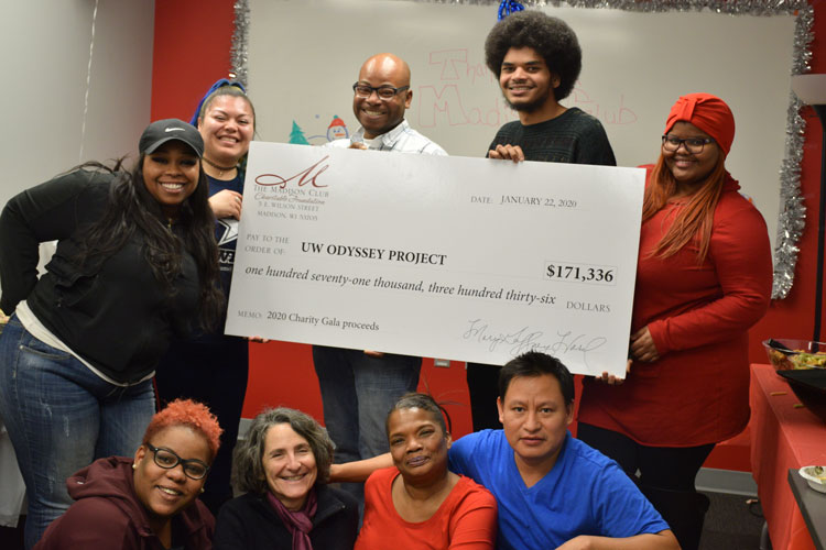 Odyssey’s award-winning Director of Development and Community Partnerships, Jenny Pressman poses with Odyssey students holding a giant check