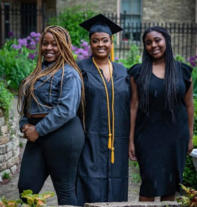  Tasha in her cap and gown posing her her daughters