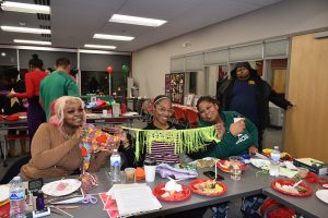 Geresa, Amanda, and Mya holding up cape making materials