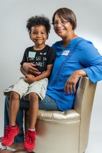 UW Odyssey Project alum sits holding a young child.