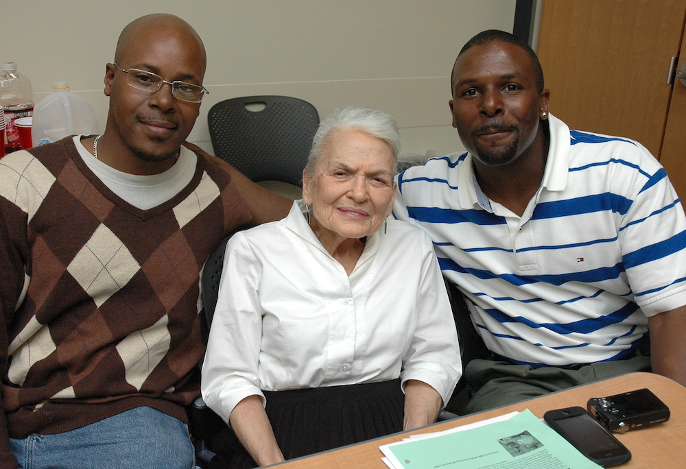 UW–Madison Odyssey Project's Wanda Auerbach sits with two students.