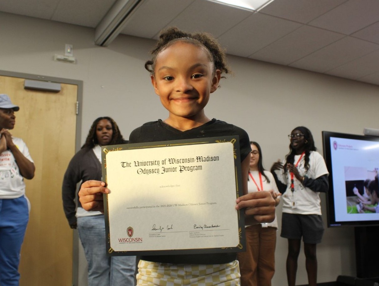 Odyssey Junior student holding graduation certificate